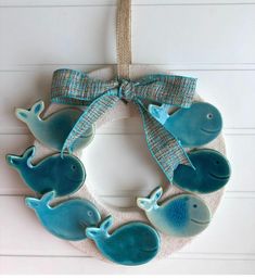 a wreath with blue whale ornaments hanging from it's side on a white wall