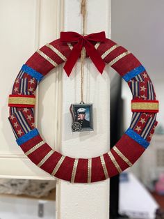 a red, white and blue patriotic wreath hanging on a door with an image of a man