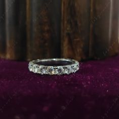 a wedding ring sitting on top of a purple cloth