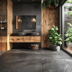 a bathroom with black tiles and wooden walls, potted plants on the counter top