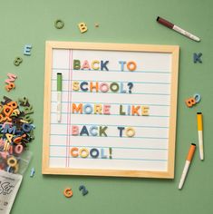 the back to school message is made out of letters and magnets on a green background