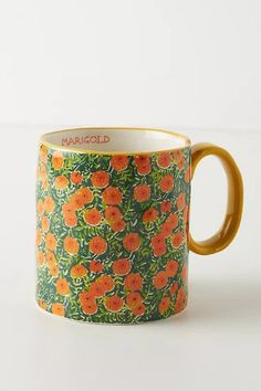 an orange and green floral print coffee mug on a white surface with the words marriold printed on it