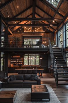 a living room filled with lots of furniture next to a stair case in front of windows