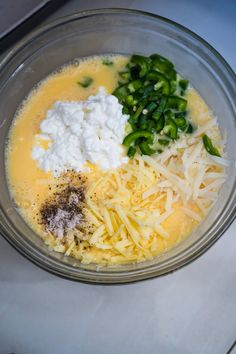 the ingredients for this dish are mixed together in a glass bowl, including cheese and green peppers