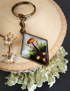 a keychain with an image of a mushroom on it sitting on a piece of wood