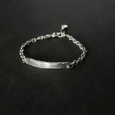 This Sterling Silver Bar and Beveled Cable Chain Bracelet is the perfect balance of minimalist and bold. Crafted with high quality sterling silver, this timeless bracelet features an organic hand-forged bar. Details: Chain: Sterling Silver Beveled Cable Chain, 4.2mm The 2” bar is hand-forged using 100% recycled sterling silver. Hand-forged, hand-formed, and hand-hammered. The edges are left raw for a look that is polished but purposefully rough. Clasp: Sterling Silver lobster claw clasp Size: ad Classic Rectangular Silver Chain Bracelet, Rectangular Sterling Silver Chain Bracelet Gift, Silver Chain Bracelet With Rectangular Solid Links, Rectangular Silver Chain Bracelet With Polished Finish, Minimalist Nickel-free Sterling Silver Chain Bracelet, Bar Bracelets, Silver Bars, Hand Forged, Recycled Sterling Silver