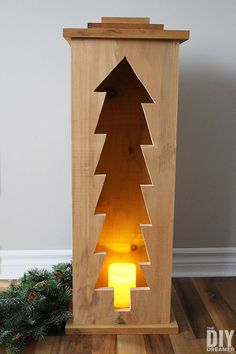 a wooden christmas tree with a lit candle in the center and text overlay that reads, christmas tree wood lantern