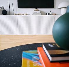 a living room with books on the table and a television in the backround