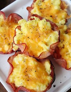 bacon and egg cups on a white plate with black pepper sprinkled on top