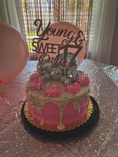 a birthday cake with pink frosting and sprinkles is on a table