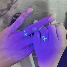 two hands with purple light on their fingers and one has the word hope written on it