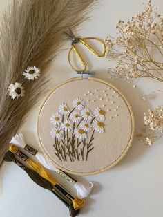 the embroidery kit is next to some flowers and scissors