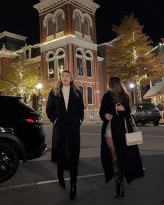 two women walking down the street at night