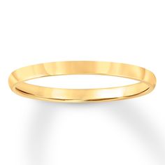 a yellow gold wedding ring on a white background