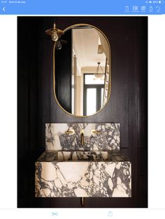 a bathroom vanity with marble counter top and gold framed mirror above it is featured on instagram