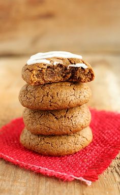 a stack of cookies sitting on top of a red cloth next to a wooden table