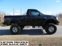 a black truck parked on the side of a road