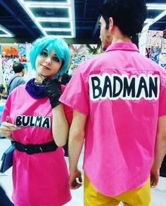 a man and woman dressed in pink shirts with the word badman on them, standing next to each other