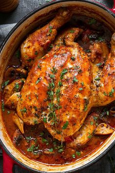 a close up of a chicken dish in a pan with garnishes on the side