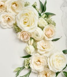 white flowers are arranged on a marble surface