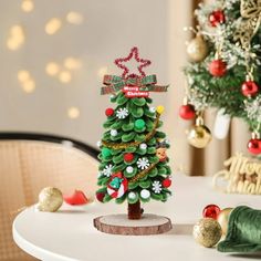 a small christmas tree sitting on top of a white table next to a green napkin