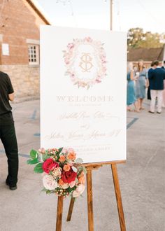 a welcome sign sitting on top of a wooden easel