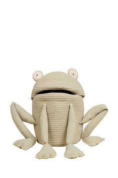 a stuffed frog sitting on top of a white floor