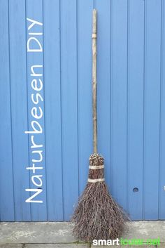 a broom leaning up against a blue wall