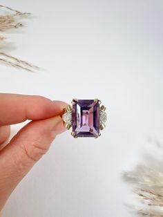 Vintage Amethyst Ring 18ct Yellow Gold Stamped Circa 1940s Introducing a stunning 18ct yellow gold cocktail ring featuring a captivating emerald-cut amethyst stone elegantly set in a lovely yellow gold setting. The dazzling beauty of the amethyst is further accentuated by diamond-set shoulders in white gold, adding a touch of sparkle and sophistication. This exquisite ring is a perfect statement piece for any special occasion and is sure to dazzle and delight. The face of the ring measures appro Vintage Amethyst Ring, Amethyst Ring Vintage, Yellow Gold Cocktail Ring, Diamond Cocktail Ring, Gold Cocktail Ring, Gold Cocktail, Diamond Cocktail Rings, Yellow Gold Setting, Diamond Set