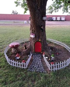 a tree that has been built into the ground with rocks around it and a red door