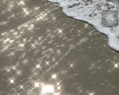 the sun shines on the sand and water at the beach