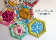 a bunch of hexagons are hanging on the wall with text that reads quilt as you go hexagons