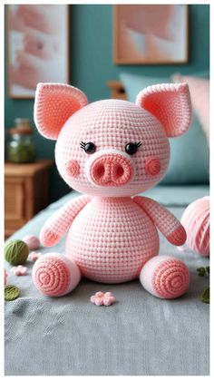 a crocheted pig sitting on top of a bed