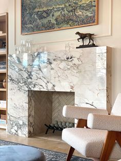 a living room filled with furniture and a painting on the wall over a fire place