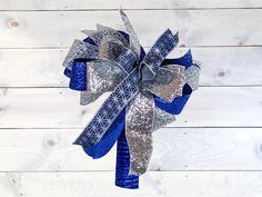 a blue and silver bow on a wooden wall