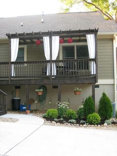 a house with white curtains on the balconies