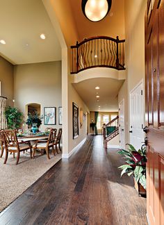 a large open floor plan with wood floors and wooden railings on the second story