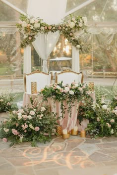 a table with flowers and candles on it in front of a large window at a wedding