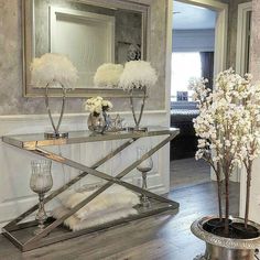 a mirrored table with vases and flowers on it