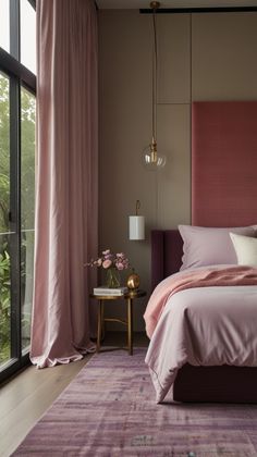 a bed with pink sheets and pillows in a bedroom next to a large glass window