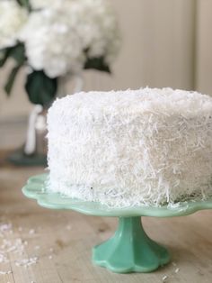 a close up of a cake on a table with flowers in the backgroud