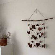 a wooden heart mobile hanging on a wall