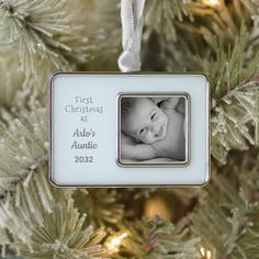 a baby's first christmas ornament hanging from a tree