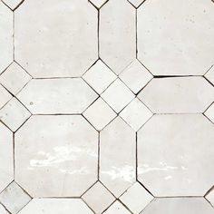 a white tiled floor with hexagonal tiles on it's sides and the top half missing