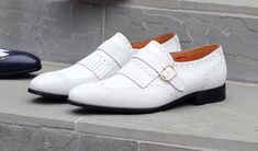 Style: 17007-8831-White Exclusive for C & E Fashions! Completely Handmade, this Matte Calfskin slip-on Loafer from the Ugo Vasare collection by Maurice features Goodyear Welted Construction, a Wingtip Design, Decorative Perforations, a Decorative Kiltie with Strap & Goldtone Buckle, and a full Leather Sole! White Tassel Loafers With Leather Sole For Formal Occasions, White Slip-on Tassel Loafers For Formal Occasions, Formal White Tassel Loafers With Leather Sole, White Tassel Loafers With Leather Sole And Round Toe, White Slip-on Tassel Loafers For Business, Elegant Slip-on Monk Strap Shoes For Spring, White Closed Toe Slip-ons For Office, White Tassel Loafers For Business, White Flat Heel Dress Shoes For Business