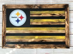 a wooden sign with a pittsburgh flag painted on it's side and the nfl logo