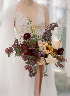 a woman in a wedding dress holding a bridal bouquet