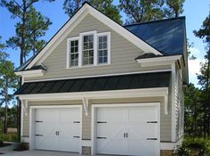 a two car garage with three windows on the top floor and one above the door