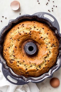 a bundt cake in a pan with chocolate chips on top and eggs around it