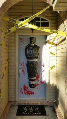 a door with yellow caution tape around it and a statue on the wall behind it